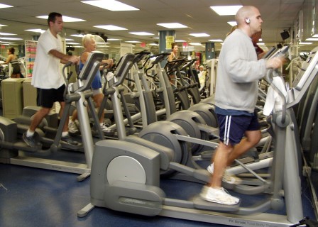 people exercising using elipticals